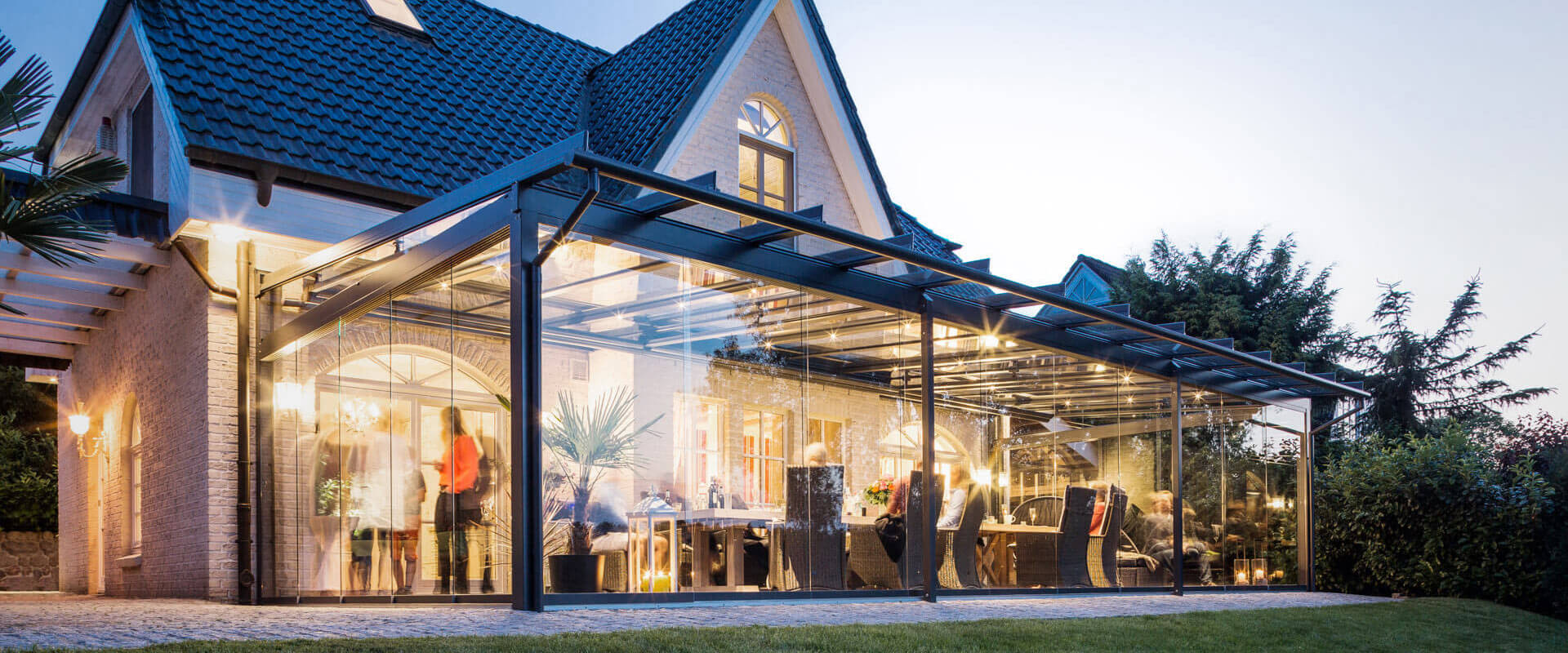 Ein Terrassendach mit einer senkrechten Verglasung Terrassendach/Glashaus in der Dämmerung